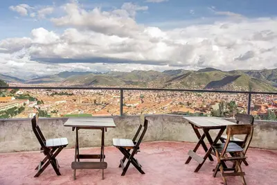 two tables and chairs on a balcony with a view at Departamentos Santa Ana Barrio Tradicional in Cusco