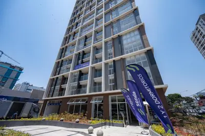 a tall building with signs in front of it at All San Isidro Apartments by Vibrant in Lima
