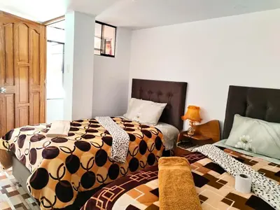 a bedroom with two beds and a bed istg at Encanto del Cusco in Cusco