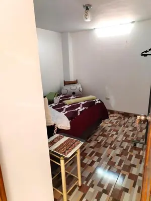 a bedroom with a bed and a wooden floor at Encanto del Cusco in Cusco