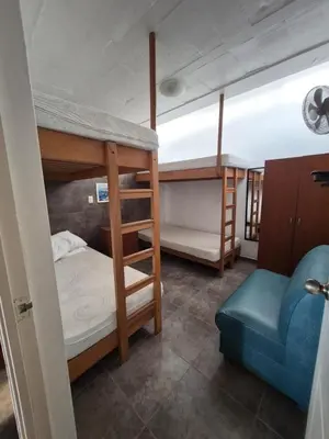 a room with two bunk beds and a blue couch at Front Beach House nearby Playa Asia in Lima, Peru! in Cerro Azul