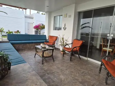 a patio with orange chairs and a blue couch at Front Beach House nearby Playa Asia in Lima, Peru! in Cerro Azul