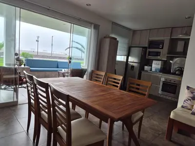 a kitchen and dining room with a wooden table and chairs at Front Beach House nearby Playa Asia in Lima, Peru! in Cerro Azul