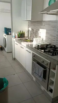 a kitchen with white cabinets and a stove top oven at Habitación in Lima