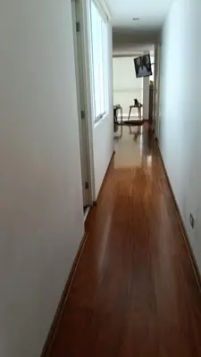 an empty hallway with a wooden floor and white walls at Habitación in Lima