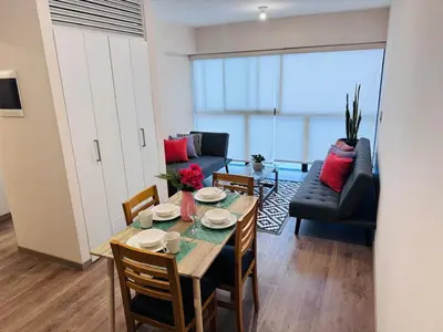 a living room with a table and chairs and a couch at M15 - Two Bedroom Apartment in front of the US Embassy in Lima