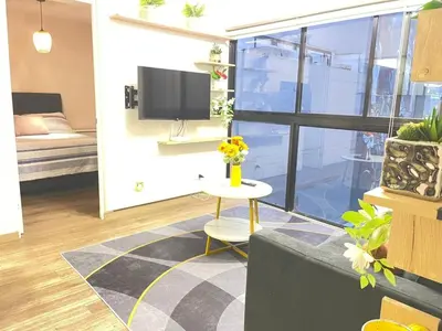 a living room with a tv and a table with flowers at M24 Departamento de 2 Dorm 2 baños - Frente Embajada de USA in Lima