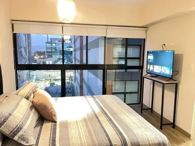 a bedroom with a bed and a flat screen tv at M24 Departamento de 2 Dorm 2 baños - Frente Embajada de USA in Lima
