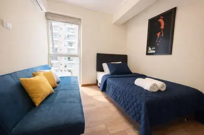 a bedroom with two beds and a couch at Amplio depa 3 habitaciones en Costanera in Lima