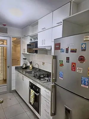 a kitchen with white cabinets and a refrigerator at Amplio depa 3 habitaciones en Costanera in Lima
