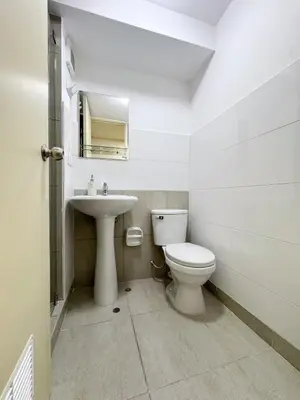 a white bathroom with a toilet and a sink at Departamento Cerca al Aeropuerto Jorge Chavez in Lima