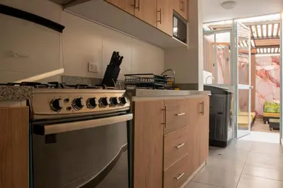 a kitchen with a stainless steel stove top oven at Departamento Cerca al Aeropuerto Jorge Chavez in Lima