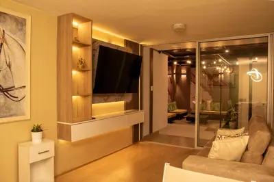 a living room with a flat screen tv on a wall at Departamento Cerca al Aeropuerto Jorge Chavez in Lima