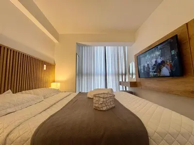 a bedroom with a large bed and a flat screen tv at Departamento 2BR Santa Beatriz cerca al Circuito Mágico del Agua Céntrico in Lima