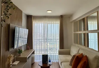 a living room with a couch and a large window at Departamento 2BR Santa Beatriz cerca al Circuito Mágico del Agua Céntrico in Lima