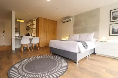 a bedroom with a large bed and a kitchen at Moderno apartamento en San Isidro in Lima