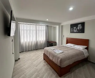 a bedroom with a bed and a flat screen tv at Hotel Altavista in Abancay