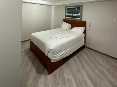 a bedroom with a large bed with white sheets at Hotel Altavista in Abancay