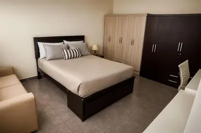 a bedroom with a large bed and a cabinet at A cozy apartment in the heart of Miraflores in Lima