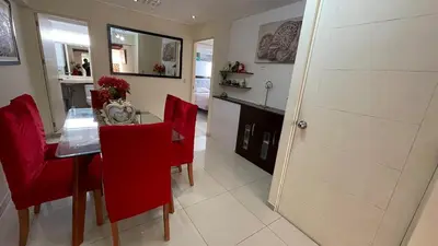 a dining room with a table and red chairs at A cozy apartment in the heart of Miraflores in Lima
