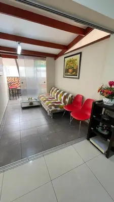 a living room with a couch and red chairs at A cozy apartment in the heart of Miraflores in Lima