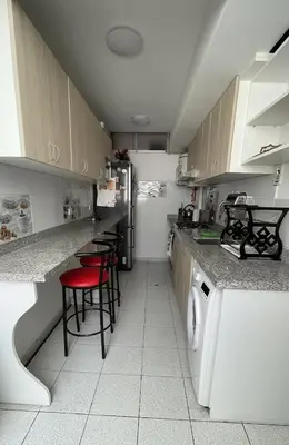 a kitchen with a refrigerator and red chairs in it at A cozy apartment in the heart of Miraflores in Lima