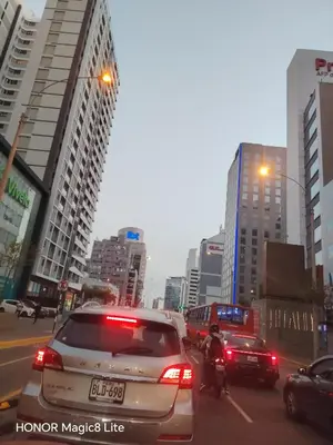 a busy city street with cars and a person on a motorcycle at Departamento The Lead 509 con Piscina in Lima