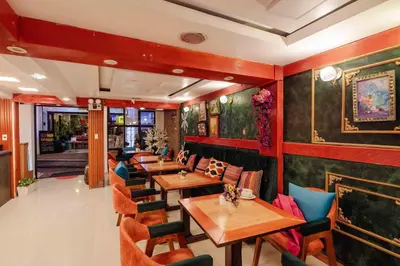 a restaurant with wooden tables and chairs and paintings on the walls at Hotel MachuPicchu Humantay in Machu Picchu