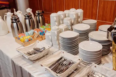 a table topped with white plates and utensils at Hotel MachuPicchu Humantay in Machu Picchu