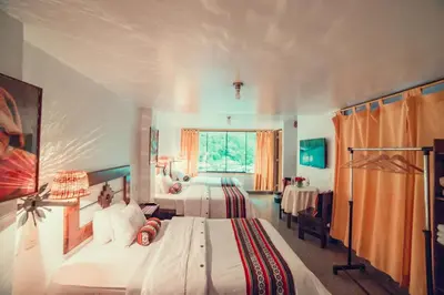 a bedroom with two beds and a window at Hotel MachuPicchu Humantay in Machu Picchu
