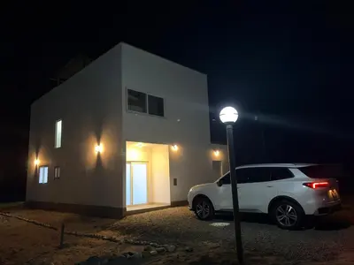 a white car parked next to a building at night at Casa de playa en Cerro Azul con piscina privada in Cerro Azul