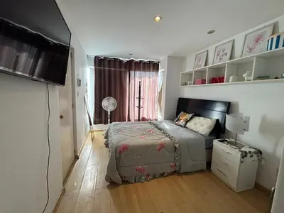 a bedroom with a bed and a flat screen tv at Casa Portada del Sol La Molina in Lima