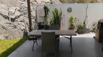 a table and chairs in a patio with plants at Casa Portada del Sol La Molina in Lima