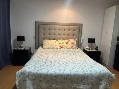 a bedroom with a large bed with two night stands at Casa Portada del Sol La Molina in Lima