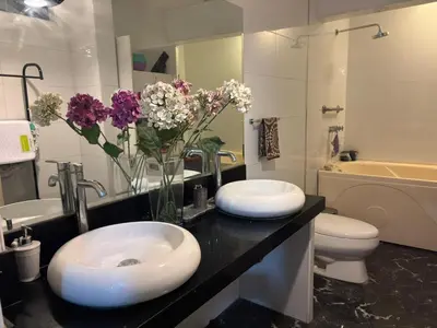a bathroom with two sinks and flowers on a counter at Casa Portada del Sol La Molina in Lima