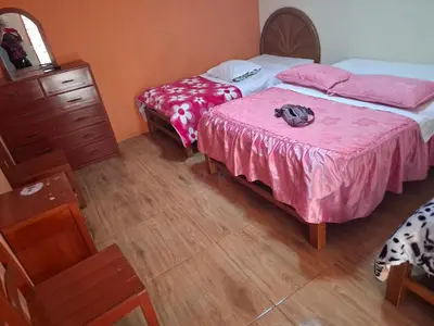 a bedroom with two beds and a dresser at Hospedaje Las Brisas in Churín
