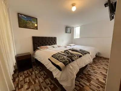 a bedroom with a large bed in a room at Qhawarina Hostel Ollantaytambo in Ollantaytambo