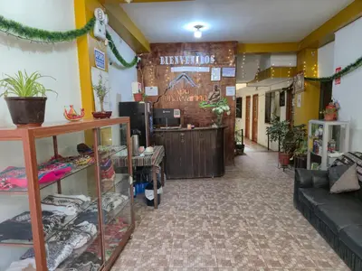 a lobby of a store with a couch and a counter at Qhawarina Hostel Ollantaytambo in Ollantaytambo