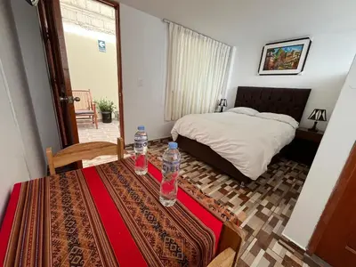 a bedroom with a bed and two water bottles on a table at Qhawarina Hostel Ollantaytambo in Ollantaytambo