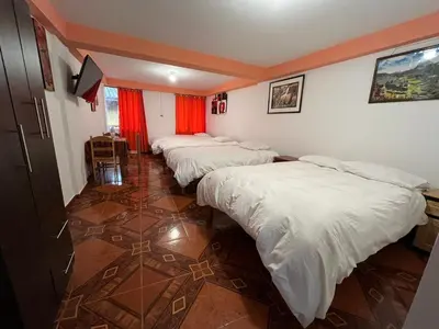 a row of beds in a room with red curtains at Qhawarina Hostel Ollantaytambo in Ollantaytambo