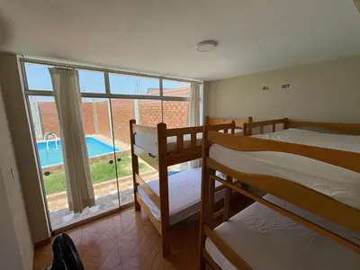 a room with two bunk beds and a large window at Casa playa in Barranca