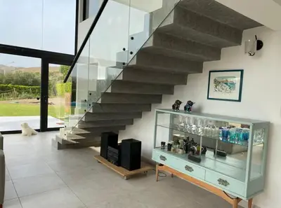 a staircase in a living room with a glass case at Casa de Campo Azpitia Perú in Santa Cruz de Flores