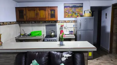a kitchen with a table and a couch in a kitchen at Victoria home san blas in Cusco