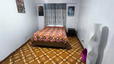 a bedroom with a bed in the corner of a room at Victoria home san blas in Cusco