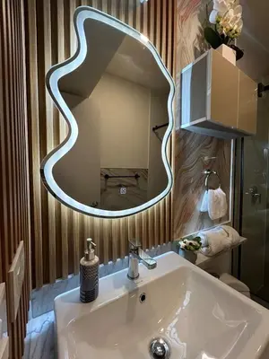 a bathroom with a white sink and a mirror at Luxury Ocean View Barranco Apt, 17th Floor AC in Lima