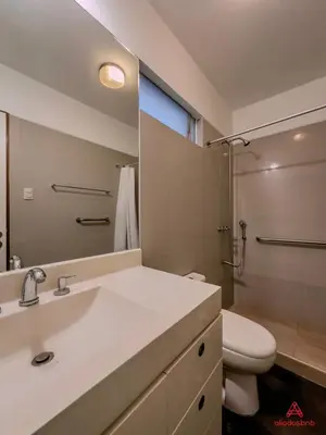 a bathroom with a sink and a toilet and a mirror at Cozy Retreat in the Heart of Surco in Lima