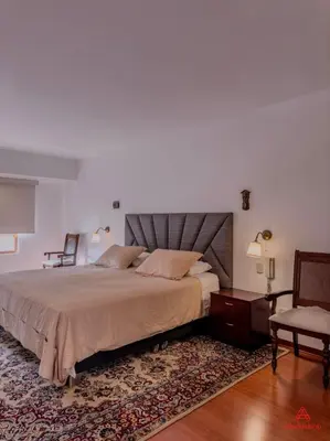 a bedroom with a large bed and a chair at Cozy Retreat in the Heart of Surco in Lima