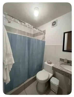 a bathroom with a toilet and a sink and a shower at Habitación con baño privado, duplex con ambientes compartidos in Lima