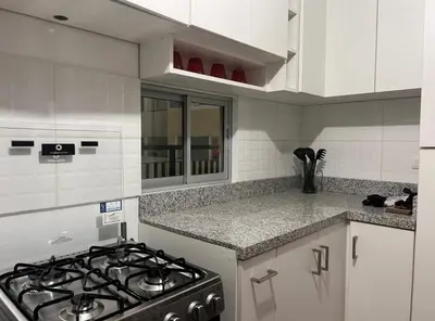 a kitchen with a stove and a counter top at Habitación con baño privado, duplex con ambientes compartidos in Lima