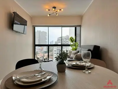 a dining room table with plates and wine glasses at Fantastic 1BR at Barranco in Lima